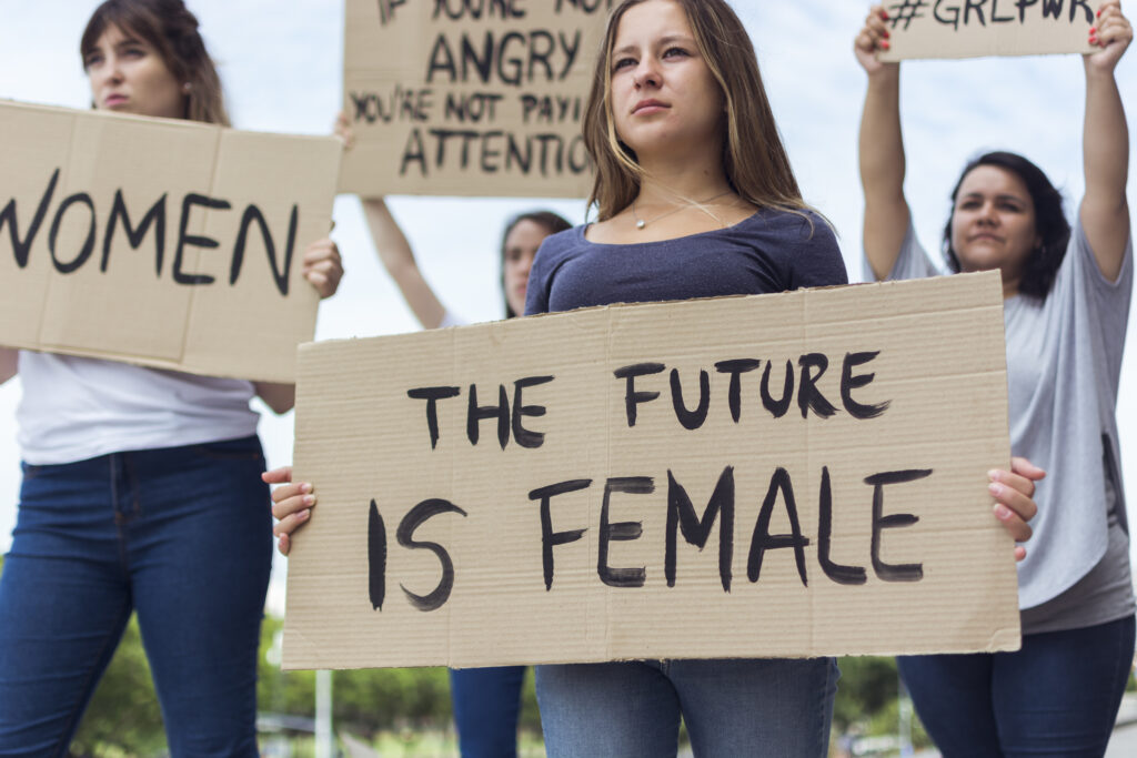 Young women protesting against gendered barriers to climate resilience.