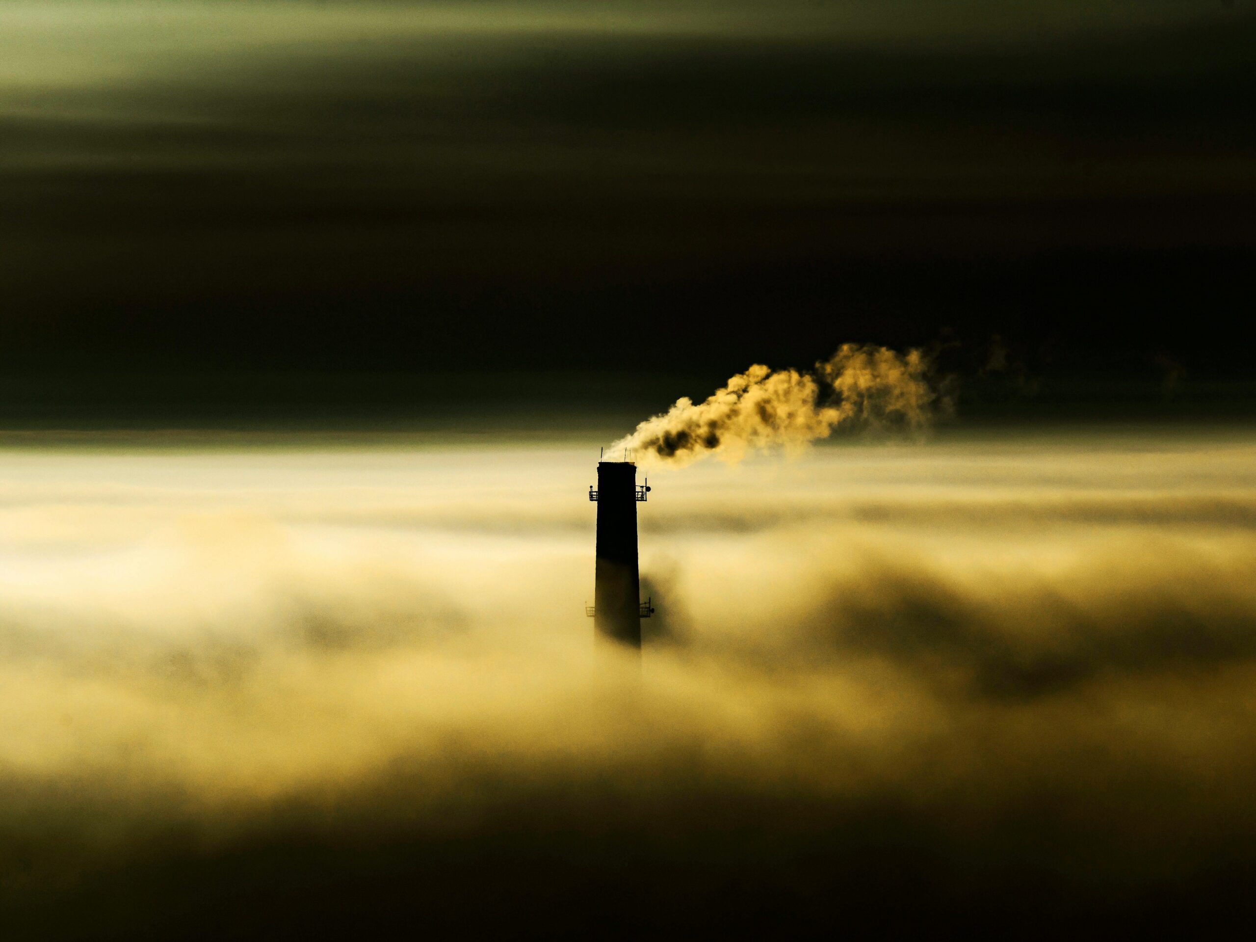 An industrial exhaust releasing toxic emissions above the clouds in the atmoshphere.