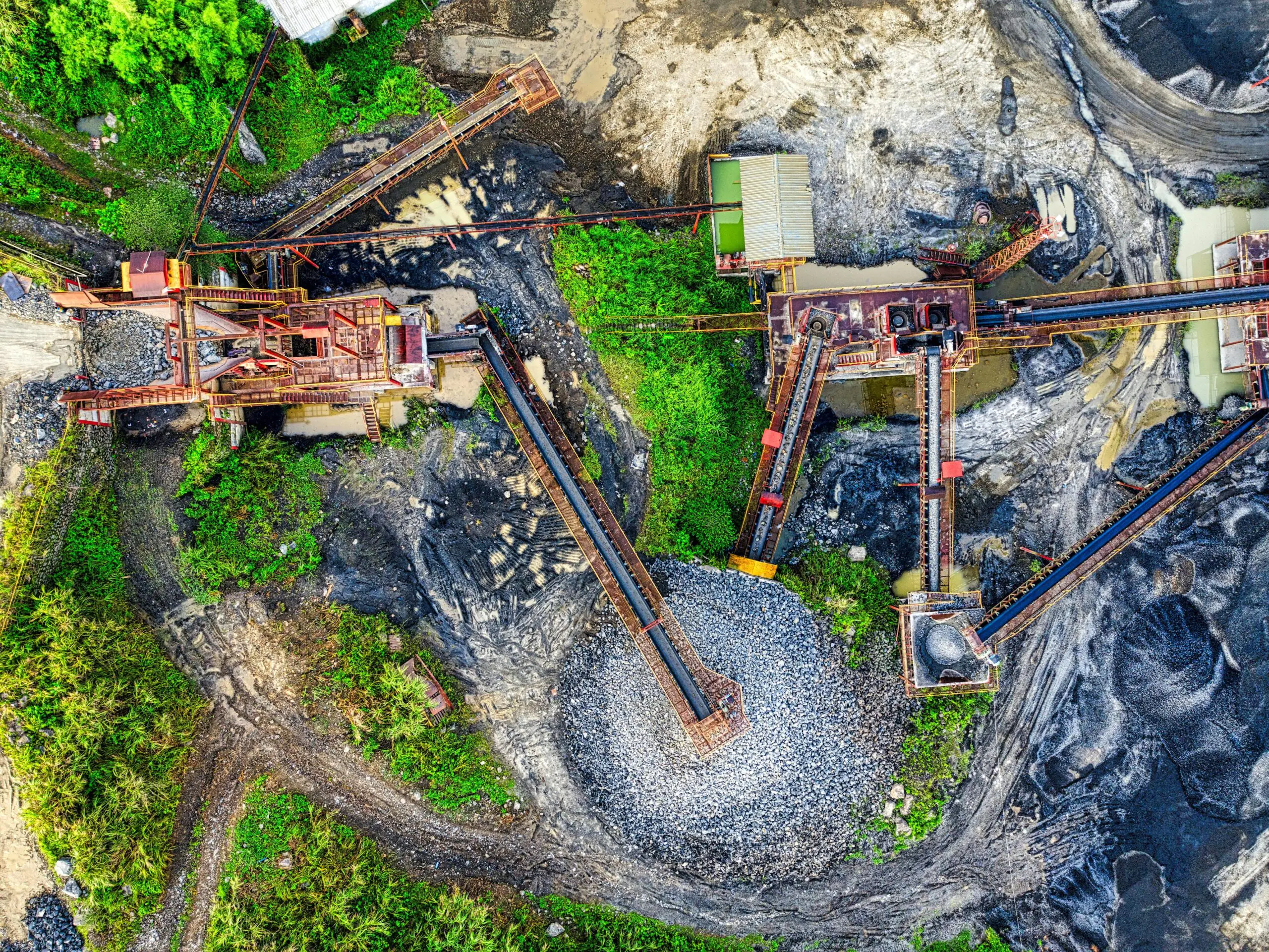 Drone view of a mining site in Rumpin, West Java with greenery and machinery.